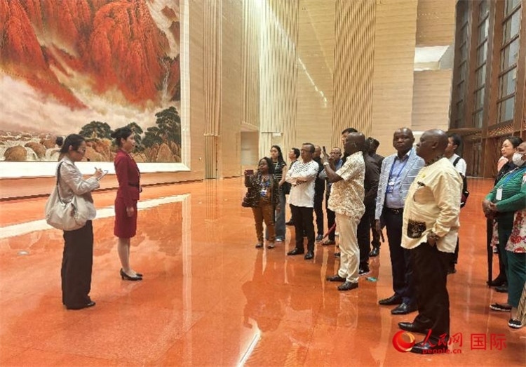 代表團(tuán)在入口處聽取講解。人民網(wǎng) 曹欣悅攝