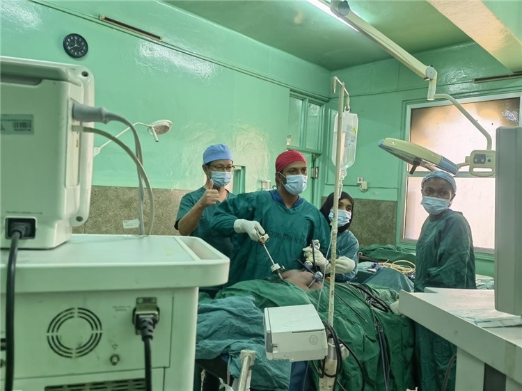 隊長蔣國慶（左一）關注當地醫(yī)生手術情況。中國援桑醫(yī)療隊供圖