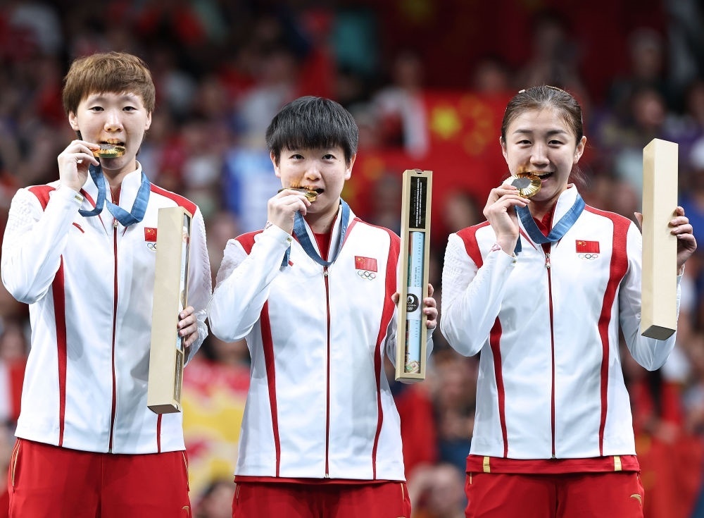 冠軍中國隊選手王曼昱、孫穎莎、陳夢（從左至右）在巴黎奧運會乒乓球女子團體頒獎儀式上（2024年8月10日攝）。新華社記者 王東震 攝