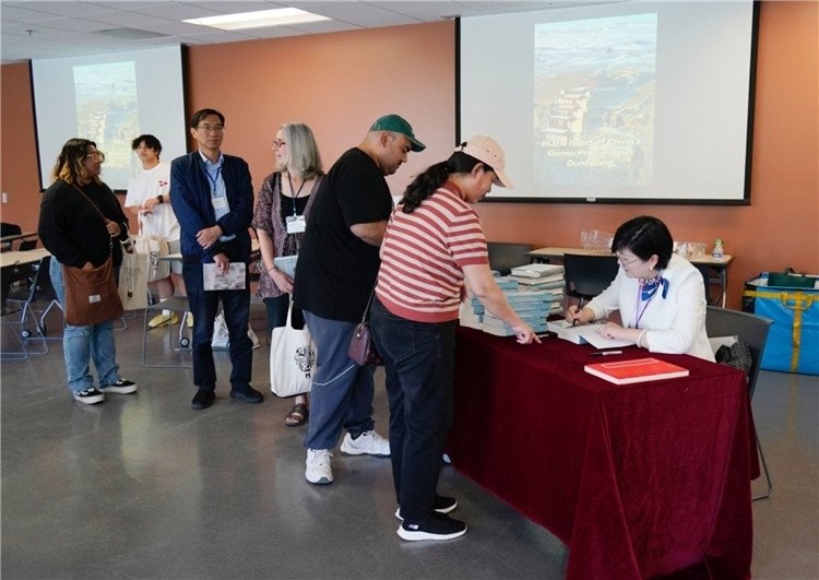 作者顧春芳在活動現(xiàn)場簽名贈書。羅先勇攝