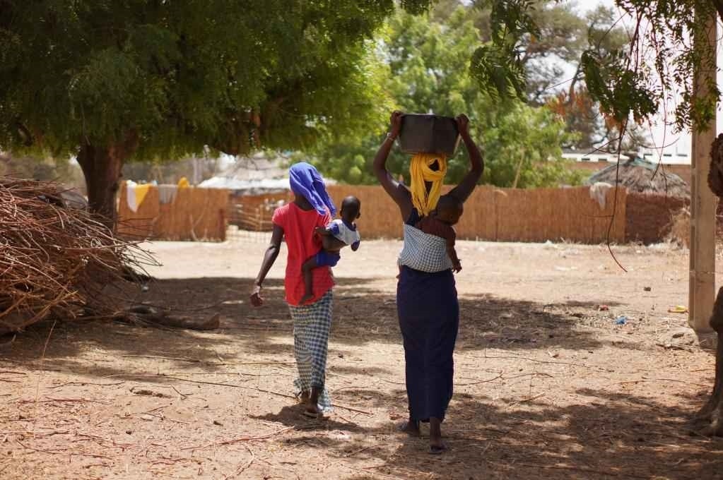 2023年3月20日，在塞內(nèi)加爾久爾貝勒區(qū)的泰內(nèi)富勒村，村民將取到的水運(yùn)回家。新華社記者 王子正 攝