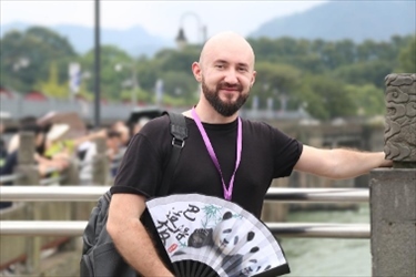 俄羅斯塔斯社執(zhí)行編輯葉夫根尼·扎多羅日內(nèi)在都江堰魚嘴拍照留念。（李佩藺 攝）