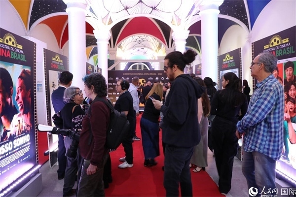 為期4天的第三屆中國－巴西電影展期間，來自中巴兩國的14部參展影片受到巴西電影愛好者和社會各界人士好評，圖為當(dāng)?shù)赜^眾在影展舉辦地巴西里約熱內(nèi)盧勞拉—阿爾維姆文化之家的迎賓廳欣賞參展電影海報。 人民網(wǎng)記者 陳一鳴攝