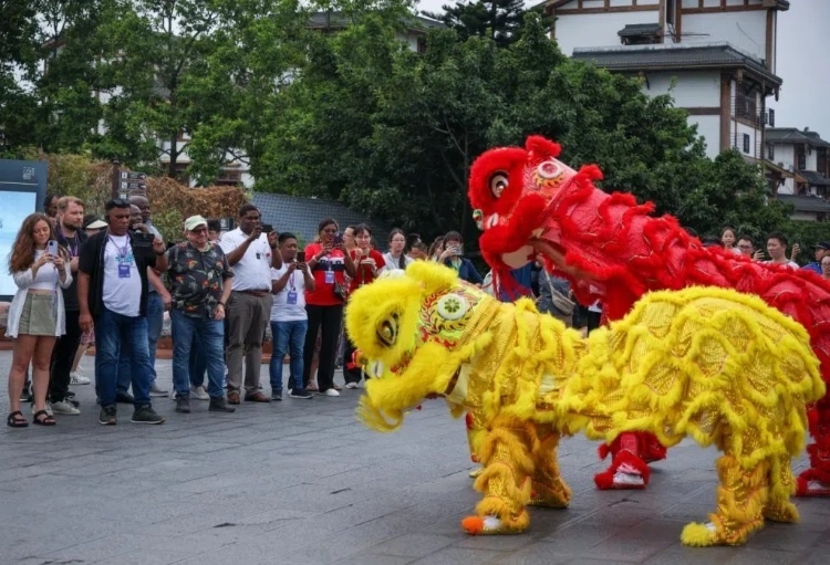 2024“一帶一路”媒體合作論壇聯(lián)合采訪調(diào)研行成員在樂山蘇稽古鎮(zhèn)觀看非遺舞獅表演。本報記者 伊霄攝