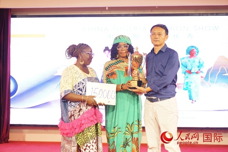 中國駐尼日利亞使館文化參贊兼中國文化中心主任李旭大（右）為最佳表現(xiàn)獎(jiǎng)?lì)C獎(jiǎng)（中）。人民網(wǎng)記者 姜宣攝