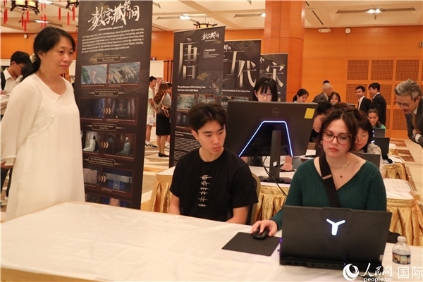 在活動(dòng)現(xiàn)場(chǎng)，當(dāng)?shù)孛癖婓w驗(yàn)“數(shù)字藏經(jīng)洞”云游戲，沉浸式體驗(yàn)敦煌文化。 人民網(wǎng)記者 李志偉攝