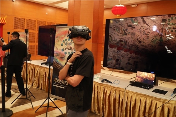 1、在本次活動(dòng)的展覽現(xiàn)場(chǎng)，敦煌研究院與騰訊展示了“數(shù)字藏經(jīng)洞”和“尋境敦煌”等創(chuàng)新互動(dòng)產(chǎn)品。圖為當(dāng)?shù)孛癖娡ㄟ^(guò)VR虛擬游覽洞窟。 人民網(wǎng)記者 李志偉攝