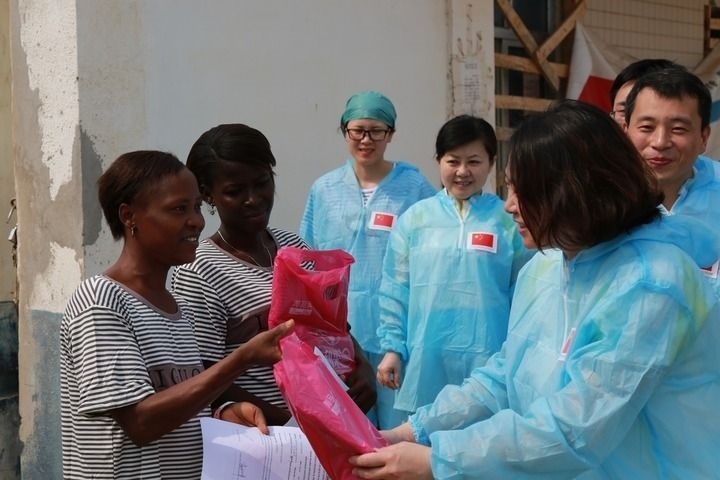 2015年4月4日，在位于塞拉利昂首都弗里敦市郊的中塞友好醫(yī)院埃博拉診療中心，中國第四批援塞醫(yī)療隊副隊長邵蔚（右前）向被治愈的埃博拉出血熱患者贈送禮物。新華社發(fā)（祖榮強(qiáng) 攝）