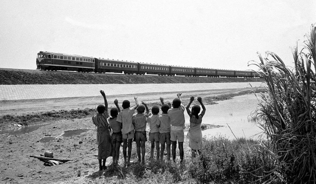 贊比亞魯西瓦西湖畔的少年兒童歡迎坦贊鐵路的列車通到他們的家鄉(xiāng)（1976年攝）。