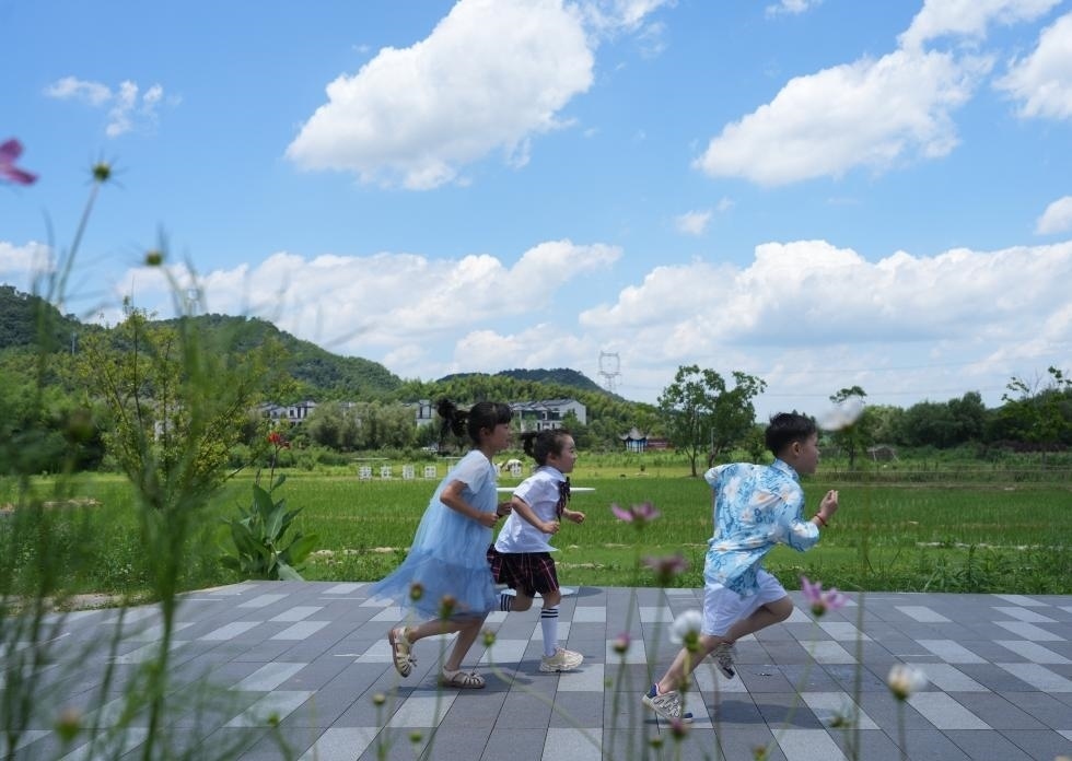 兒童在余姚市梁弄鎮(zhèn)的田野間奔跑（7月3日攝）。新華社記者翁忻旸 攝