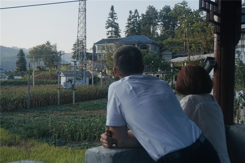 望得見山，看得見水，記得住鄉(xiāng)愁。每個人心中都有一個屬于自己的“花茂村”，在這方心田，走遍千山萬水，鄉(xiāng)音未改鬢毛衰。吉爾吉斯斯坦《比什凱克晚報》第一副總編輯妮娜·尼奇博洛娃與《中國與俄羅斯》雜志社社長奧列格·別列日內(nèi)赫攝在花茂村民居屋檐下并肩佇立，眺望山水，尋覓鄉(xiāng)愁。（李光裕攝）