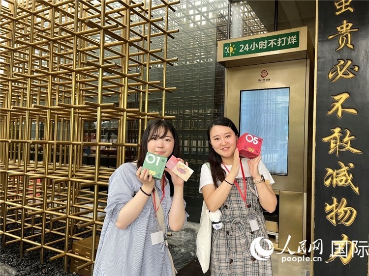 5. 代表團(tuán)團(tuán)員展示通過無人售藥機(jī)購買的盲盒。（人民網(wǎng)記者陳思 攝）