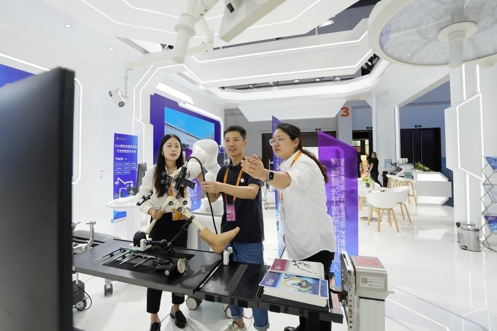 9月11日，一位媒體記者（中）在2024年服貿(mào)會國家會議中心會場體驗(yàn)北京納通科技集團(tuán)有限公司的膝關(guān)節(jié)置換手術(shù)機(jī)器人。新華社記者鞠煥宗 攝
