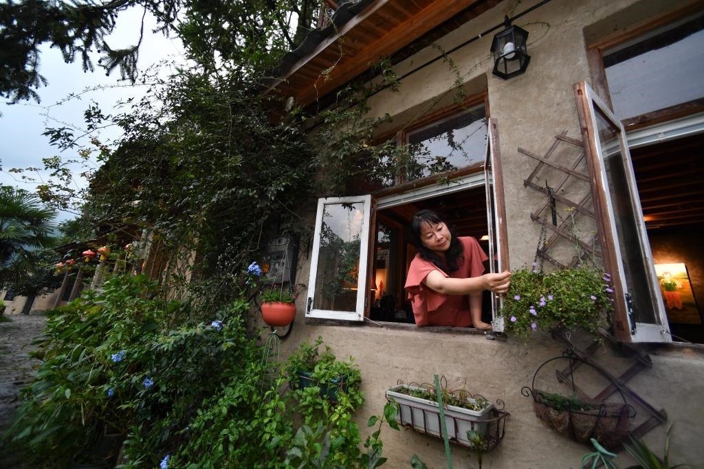 8月29日，在福建省屏南縣熙嶺鄉(xiāng)，龍?zhí)洞濉靶麓迕瘛泵泛暝诖蚶碜约航?jīng)營(yíng)的民宿外墻裝飾花盆。新華社記者姜克紅 攝