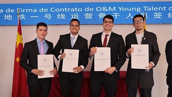 當地時間9月13日，40名哥倫比亞青年與中企承建運營的波哥大地鐵一號線項目簽約，不久將前往中國進行為期15個月的專業(yè)地鐵知識培訓。圖為部分學員在簽約儀式上展示所簽的協議。 波哥大地鐵一號線項目供圖