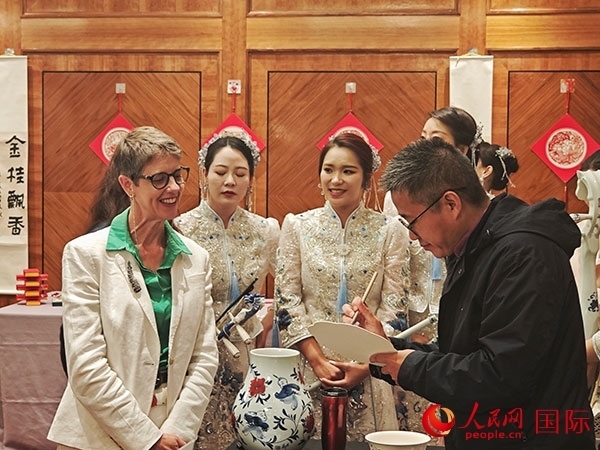 現(xiàn)場的非遺傳承人為英國觀眾展示畫技。人民網(wǎng)記者 邢雪攝