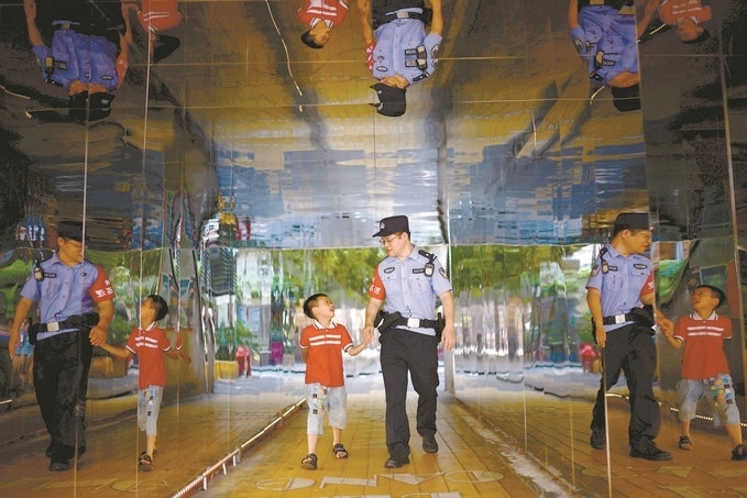 ?7月16日，重慶市公安局江北區(qū)分局一名民警在巡邏途中遇到一個獨自玩耍的小男孩，民警將其送回家。王洪平攝