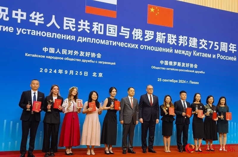 楊萬(wàn)明會(huì)長(zhǎng)和莫爾古洛夫大使為10位中俄青年友好微視頻創(chuàng)意大賽獲獎(jiǎng)代表頒獎(jiǎng)。人民網(wǎng)記者 李明琪攝