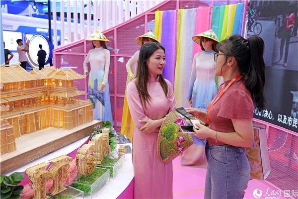 參觀者在東博會(huì)越南展區(qū)同工作人員咨詢交談。人民網(wǎng)記者 趙益普攝