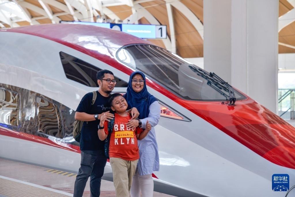 4月17日，在印度尼西亞雅加達(dá)哈利姆站站臺(tái)，乘客和雅萬(wàn)高鐵高速動(dòng)車(chē)組列車(chē)合影。新華社記者 徐欽 攝