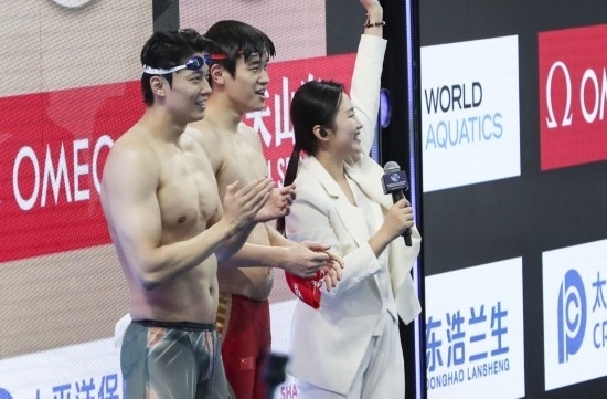  10月18日，汪順（左）和潘展樂在男子100米混合泳決賽后。新華社記者 方喆 攝