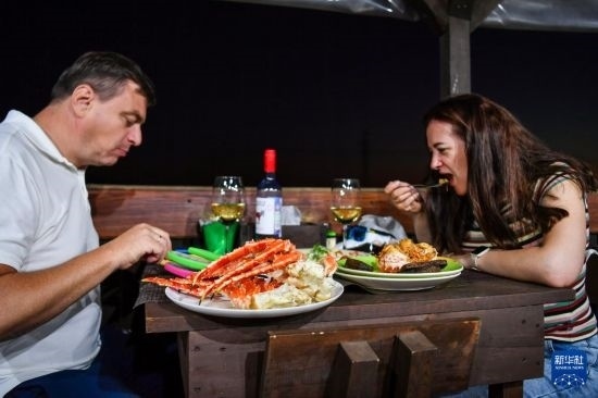9月2日，食客們在俄羅斯符拉迪沃斯托克的一家餐館品嘗帝王蟹。新華社記者 曹陽 攝