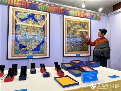 熱貢藝術(shù)國家級代表性傳承人夏吾角向嘉賓介紹作品。人民網(wǎng)記者 簡承淵攝