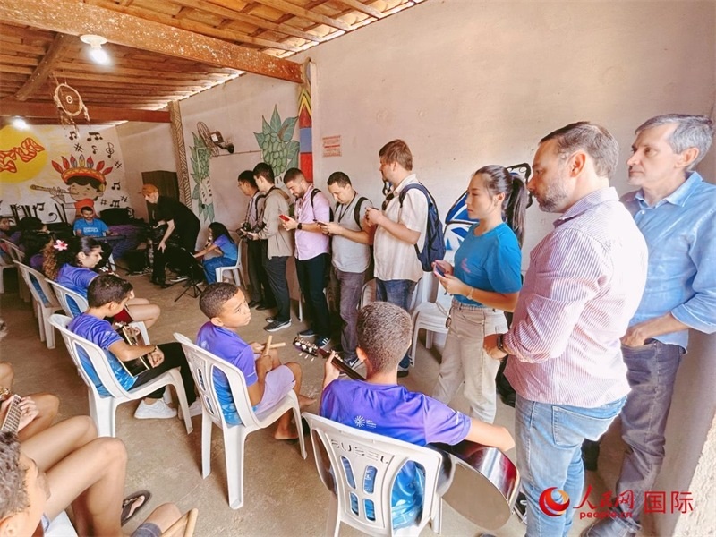  受益于中國企業(yè)的“青少年成長”項目，700多名當(dāng)?shù)厍嗌倌甑囊魳泛妥闱驂粝氩迳狭顺岚?。圖為聯(lián)合采訪團正在采訪參加音樂培訓(xùn)的孩子們。 人民網(wǎng)記者 陳一鳴攝