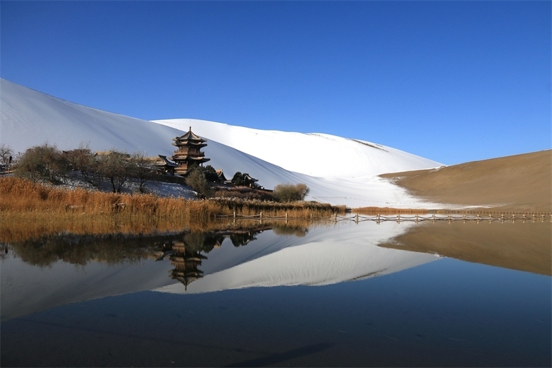 鳴沙山月牙泉景區(qū)雪景。敦煌市委宣傳部供圖，張曉亮攝