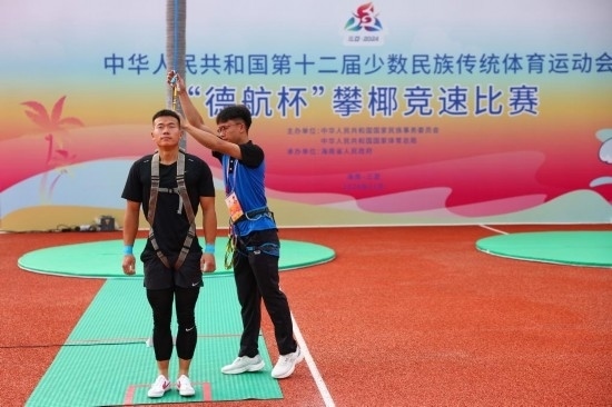 11月23日，工作人員為上海隊選手付樂樂（左）系安全繩。新華社記者 楊植森 攝