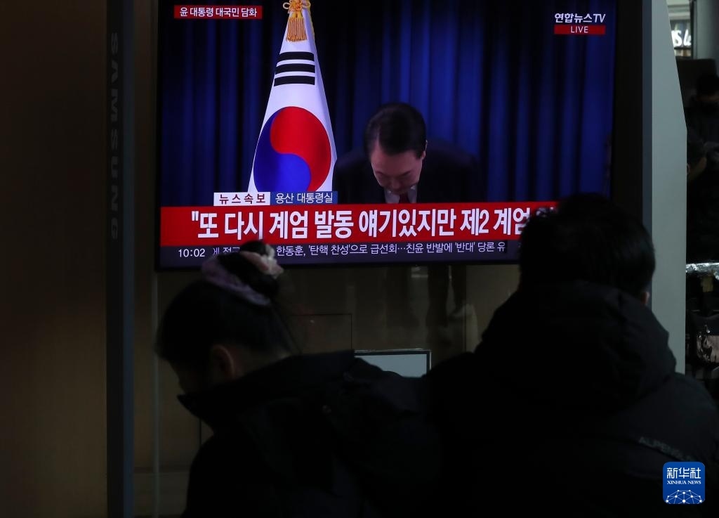 12月7日，在韓國(guó)首爾火車站，民眾觀看總統(tǒng)尹錫悅發(fā)表講話的電視畫(huà)面。新華社記者 姚琪琳 攝