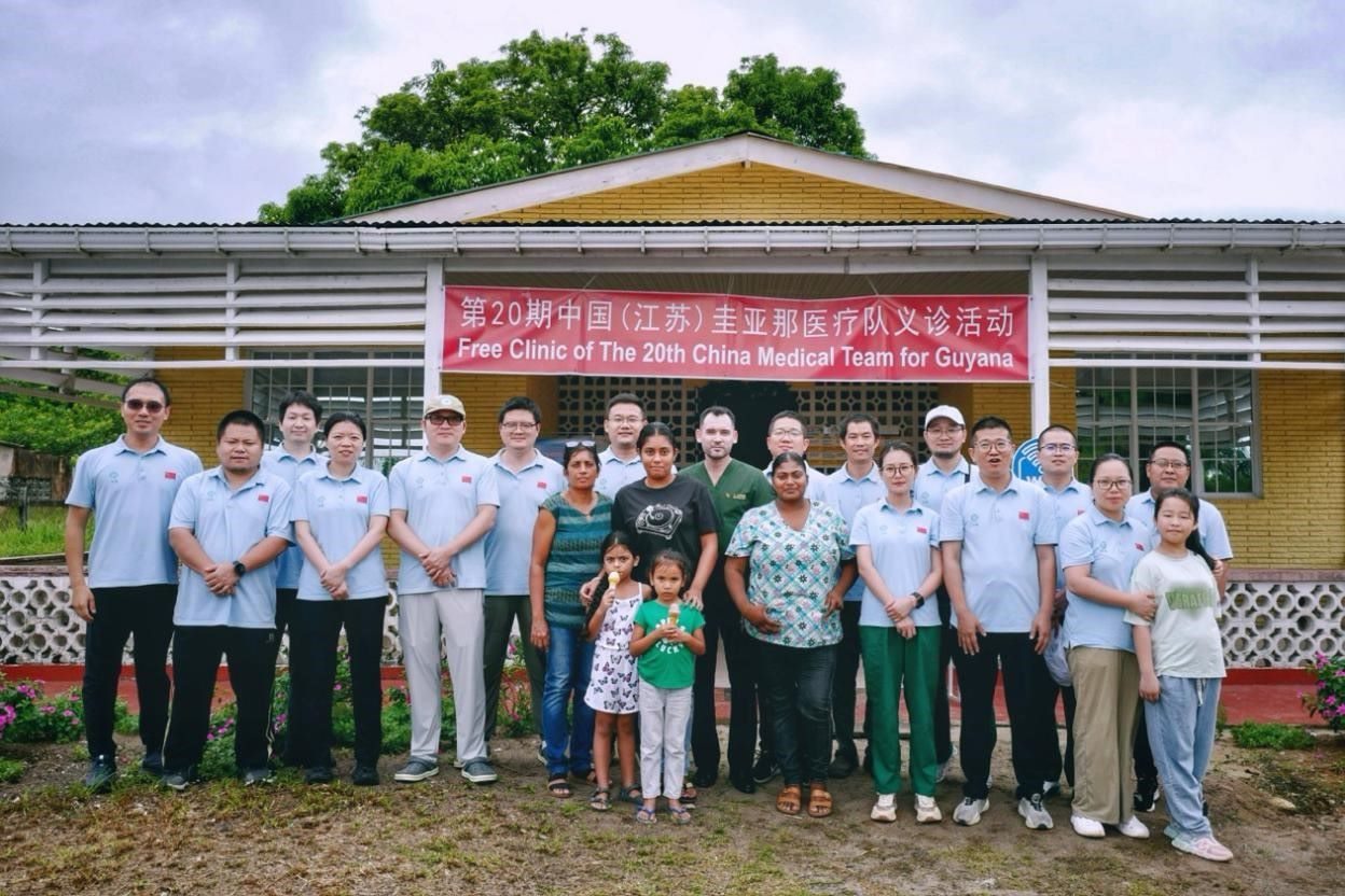 第20期中國（江蘇）援圭亞那醫(yī)療隊在圭偏遠(yuǎn)的林登高速社區(qū)開展義診后，與部分當(dāng)?shù)鼐用窈嫌啊?中國援圭醫(yī)療隊供圖