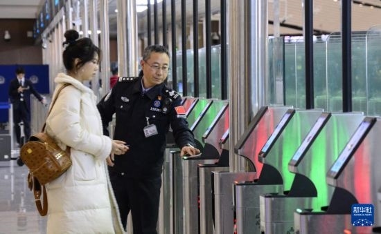 1月2日，大興機(jī)場(chǎng)邊檢站警察指導(dǎo)旅客使用自助出境設(shè)備。新華社記者 李欣 攝