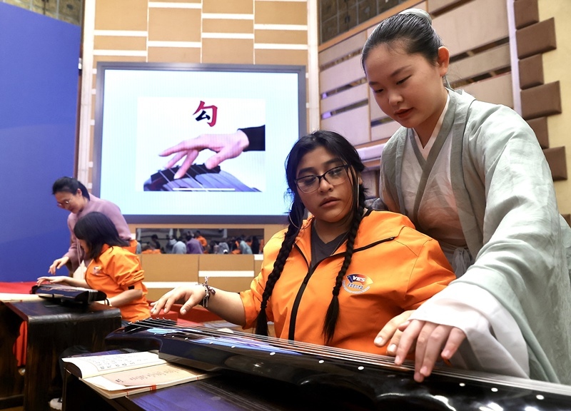 2024年3月20日，美國華盛頓州中學生代表團北京大學交流活動在北京大學英杰交流中心舉行。圖為來自華盛頓州的中學生體驗古琴。