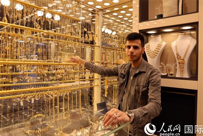 一名銷售員展示黃金飾品。人民網(wǎng) 伊納斯·易卜拉欣攝