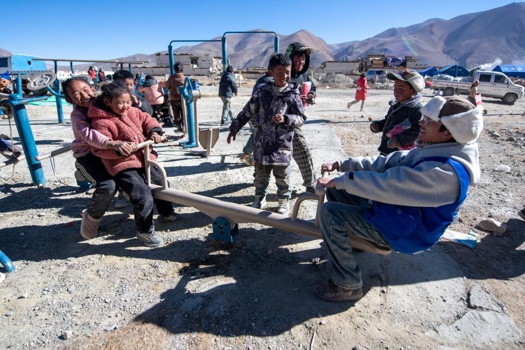 1月11日，在定日縣措果鄉(xiāng)塘仁村安置點(diǎn)，西藏星光社會(huì)工作服務(wù)中心志愿者和孩子們一起玩耍，進(jìn)行災(zāi)后心理疏導(dǎo)。人民網(wǎng)記者 翁奇羽攝