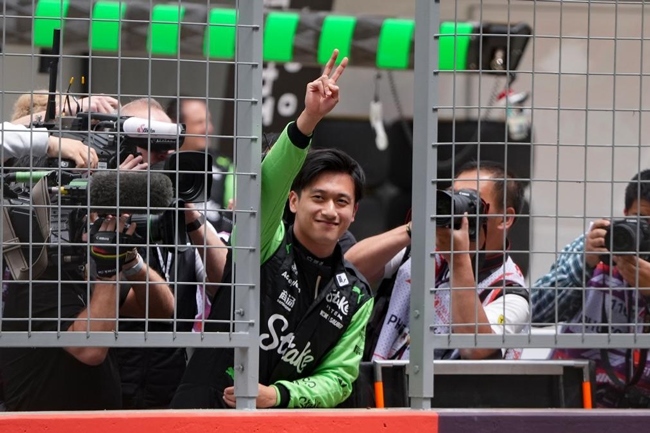 2024年4月19日，索伯車(chē)隊(duì)中國(guó)車(chē)手周冠宇（中）在練習(xí)賽前向觀眾致意。當(dāng)日，F(xiàn)1中國(guó)大獎(jiǎng)賽在上海開(kāi)賽。中國(guó)車(chē)手周冠宇主場(chǎng)首秀參賽。新華社記者 夏一方攝