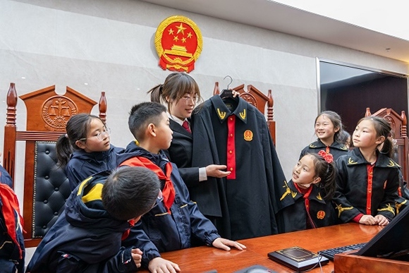 圖②：干警向同學們介紹法袍。