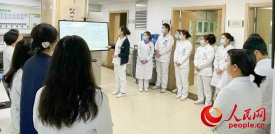 華西第四醫(yī)院姑息醫(yī)學(xué)科交班會上，護(hù)士介紹患者情況。人民網(wǎng)記者 金慧慧攝