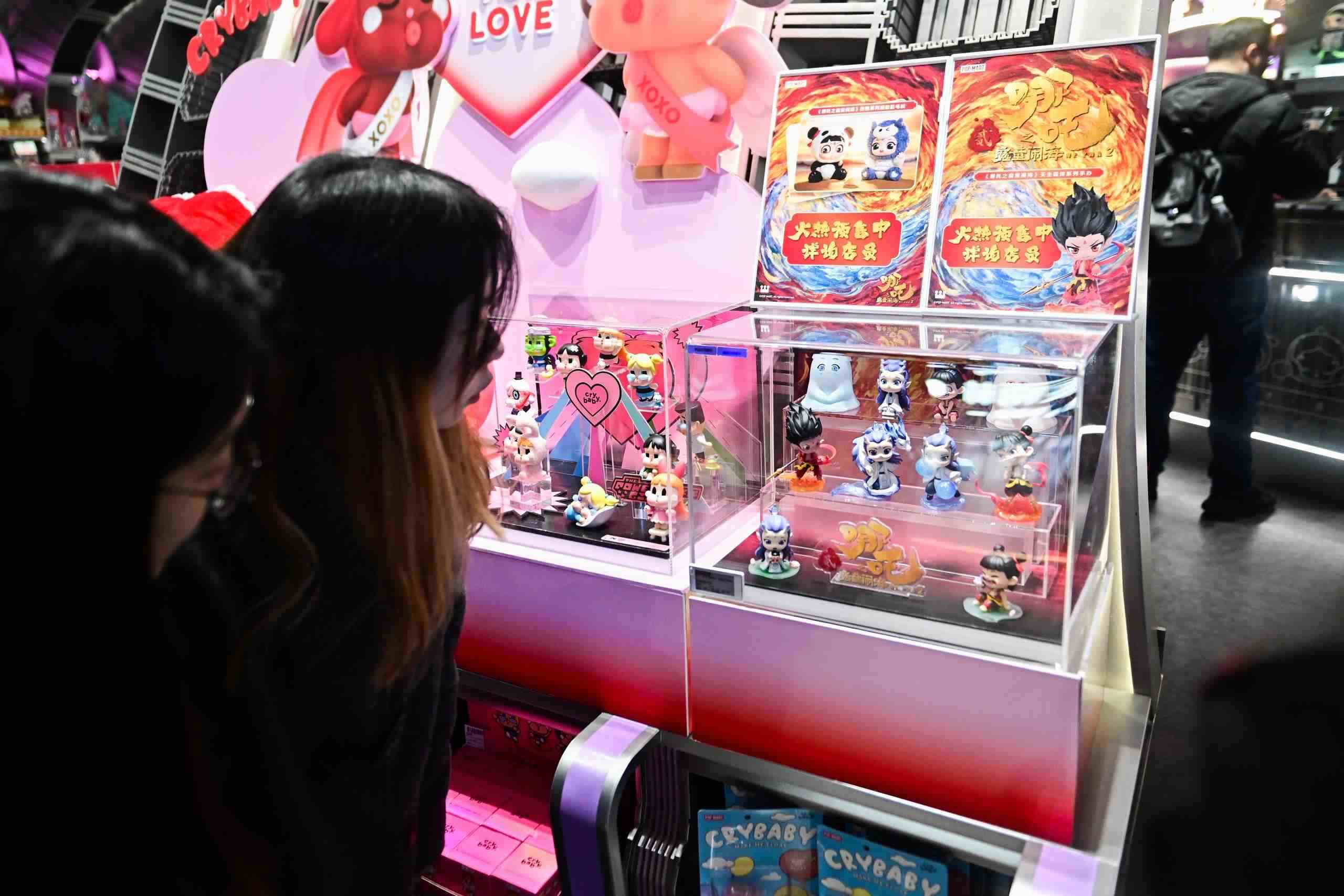 △2025年2月22日，上海，市民在圍觀《哪吒之魔童鬧?！废嚓P(guān)手辦盲盒。