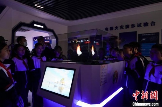 圖為學生們參觀道里區(qū)消防救援大隊消防科普體驗館內(nèi)幻影成像燃燒三要素實驗臺。中新社記者 趙宇航 攝