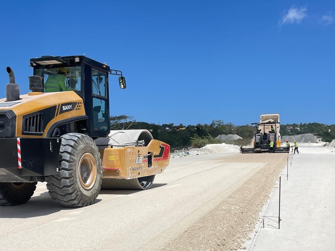 圖為中企承建的牙買(mǎi)加蒙特哥貝繞城路項(xiàng)目基層試驗(yàn)段正在進(jìn)行攤鋪和碾壓施工，相關(guān)施工工作已于日前順利完成。中國(guó)港灣美洲區(qū)域公司供圖