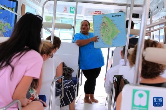 3月15日，一名導游在游艇上為游客介紹塞舌爾拉迪格島。新華社記者 董江輝 攝