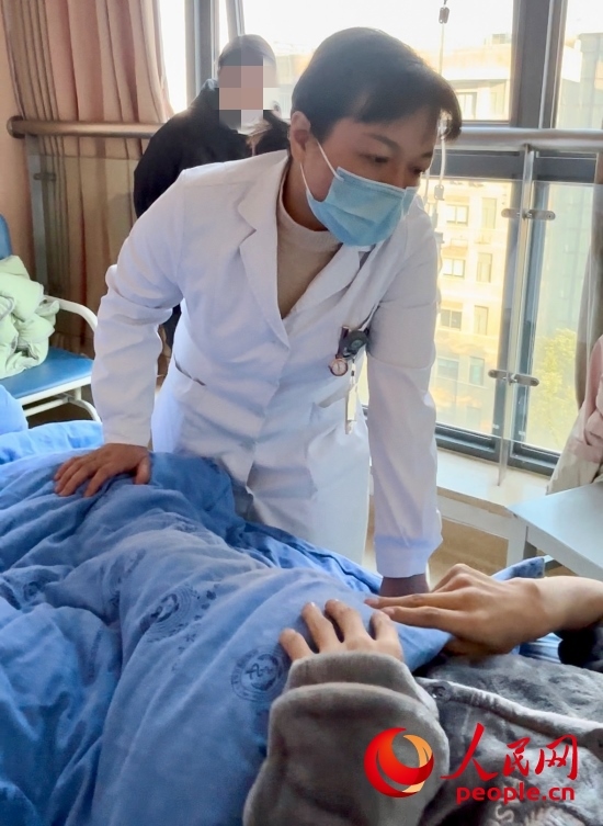 鄧茜查房時(shí)詢問(wèn)患者情況。人民網(wǎng)記者 金慧慧攝