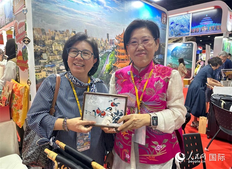 中國(guó)“大冶刺繡”傳承人劉小紅（右）參加泰國(guó)國(guó)際旅游展，向觀眾介紹中國(guó)非遺刺繡針?lè)āＨ嗣窬W(wǎng)記者 簡(jiǎn)承淵攝