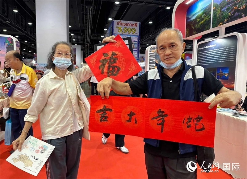2025蛇年春節(jié)，泰國(guó)市民展示他們領(lǐng)到的華人手寫(xiě)春聯(lián)。人民網(wǎng)記者 簡(jiǎn)承淵攝