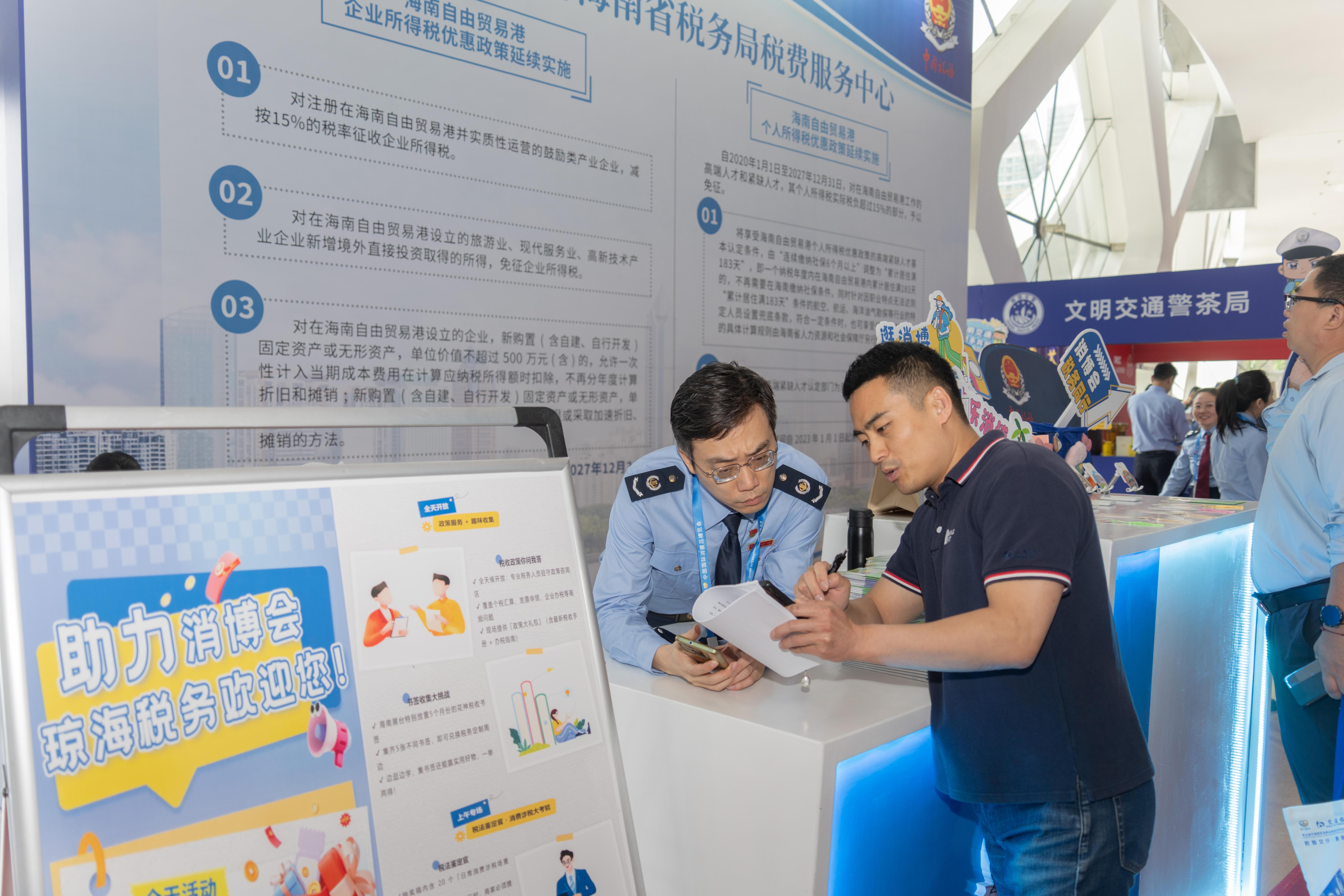 稅務(wù)服務(wù)臺工作人員向記者介紹服務(wù)參展外商的具體舉措。人民網(wǎng)記者 許崢攝