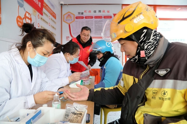 2025年3月5日，志愿者在山東省棗莊市市中區(qū)一工會驛站為外賣員免費測量血糖。新華社發(fā)（王海楠攝）