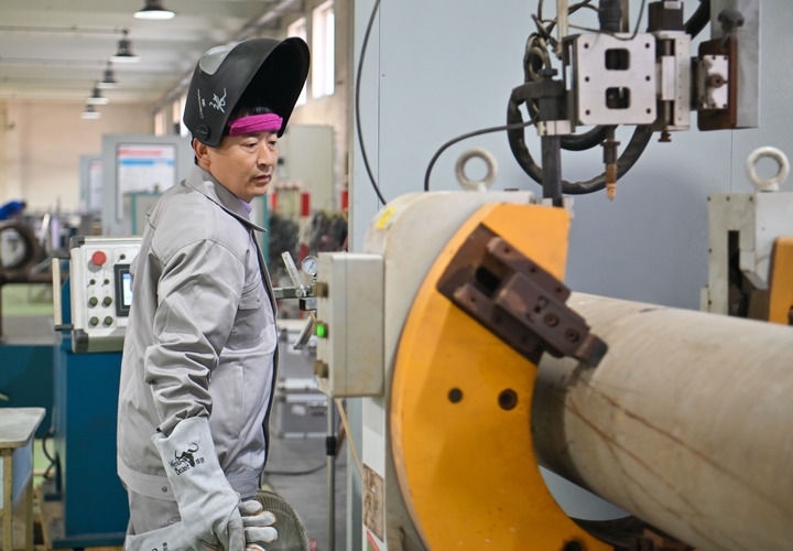 在中石化第四建設有限公司工匠學院，全國人大代表、中石化第四建設有限公司工匠學院焊接教練張振連操作自動焊機（2025年2月21日攝）。新華社記者 孫凡越 攝