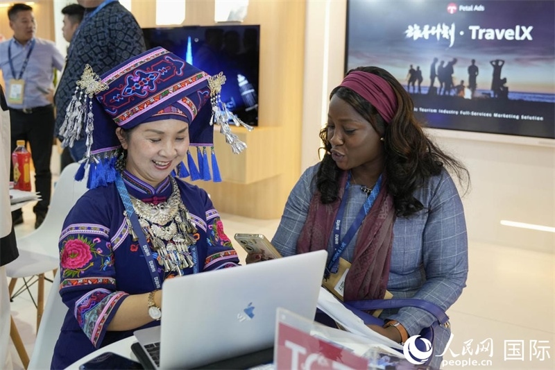 來自廣西的旅游業(yè)者同客戶交流。人民網(wǎng)塔里克·易卜拉欣攝